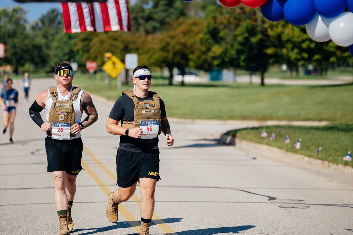 two men running with packs on backs